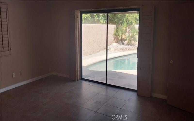 primary bedroom with view of and direct access to pool