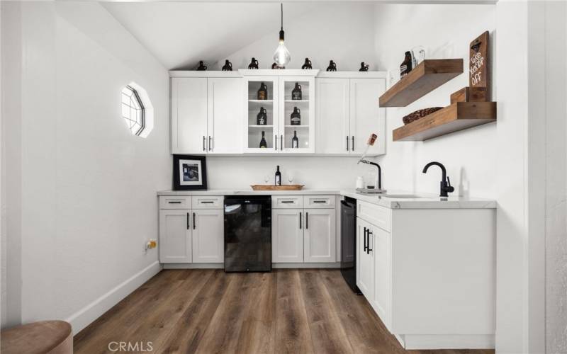 Custom wet bar just of the dining room with, all new cabinets, wine refrigerator and spout for keg.