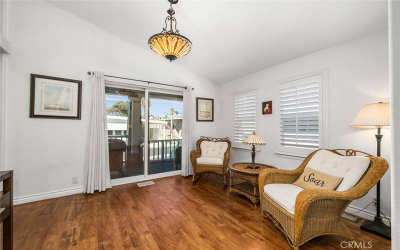 Sitting room with sliding glass door leading to cozy covered front porch.

