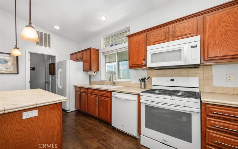 Whirlpool kitchen appliances included refrigerator, dishwasher, freestanding gas range, microwave oven.