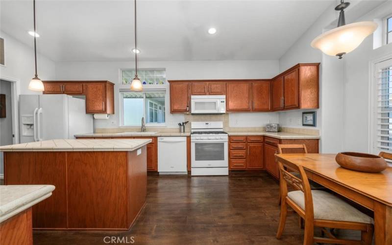 Kitchen offers high ceilings, stylish pendant lighting over the island and recessed lights.