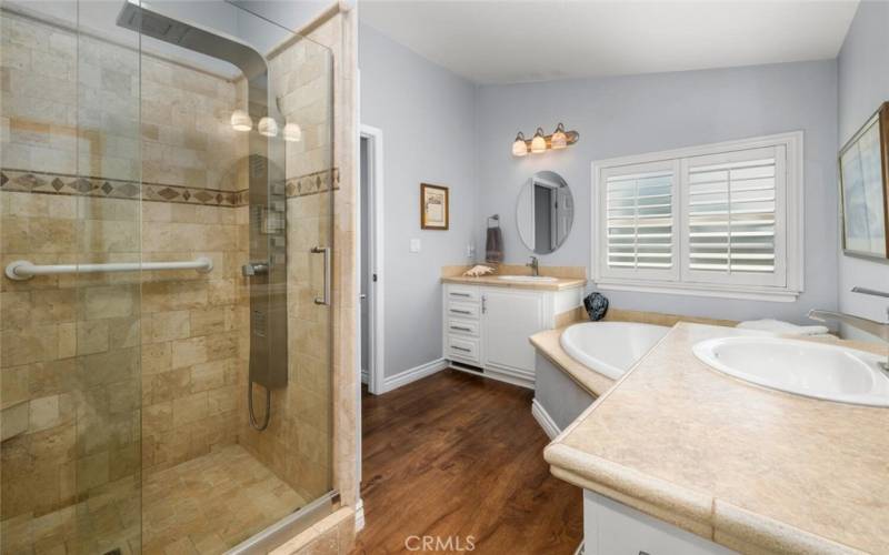 Master bathroom boasting a multi output shower head with tasteful tilework and shoer door.