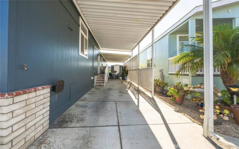 Covered carport with concrete slab driveway.