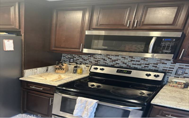 Kitchen has Attractive Cabinets and Backsplash