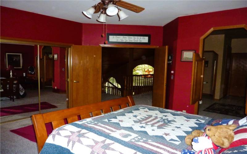 The master bedroom features mirrored closet doors and a double entry door from the hallway at the top of the stairs.