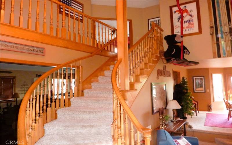 From the front door, you look up the winding staircase to the balcony and the bedrooms above.