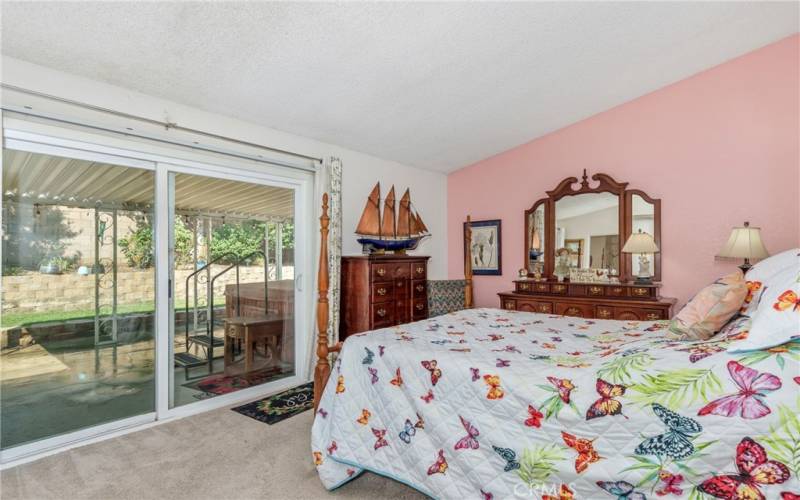 Primary bedroom with it's own bathroom and patio doors