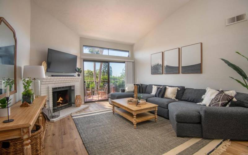 Spacious living room filled with light with a large patio through the sliders.