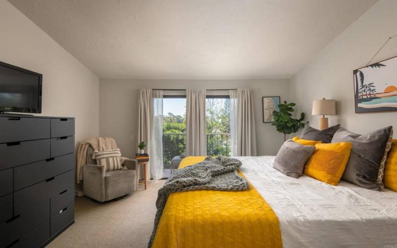 Spacious primary bedroom with sliding doors out to a patio.