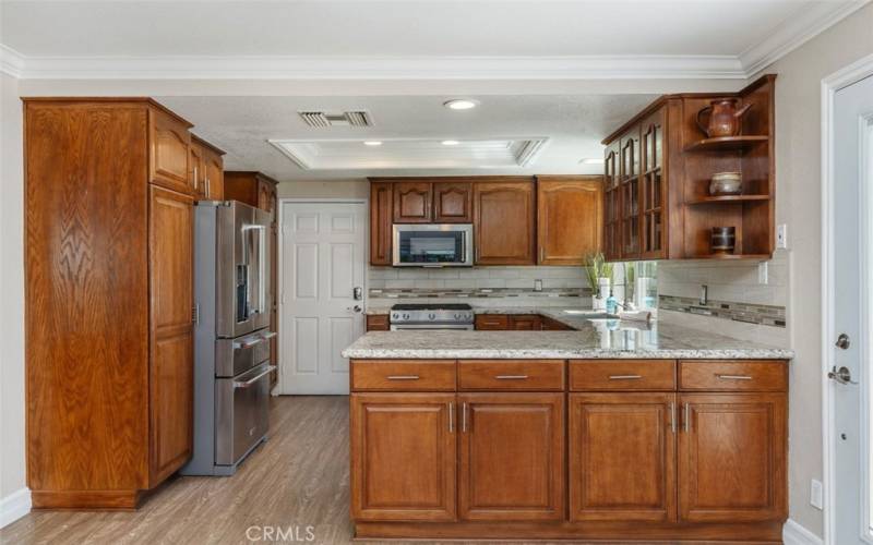 The kitchen features recessed lighting, stainless appliances, rich cabinetry and natural polished granite counters.