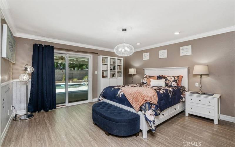 The primary suite is sumptuous! With recessed reading lights, a slider that opens to the resort-inspired rear yard, a remodeled bath, and ENORMOUS walk-in closet, life feels like a permanent vacation here!