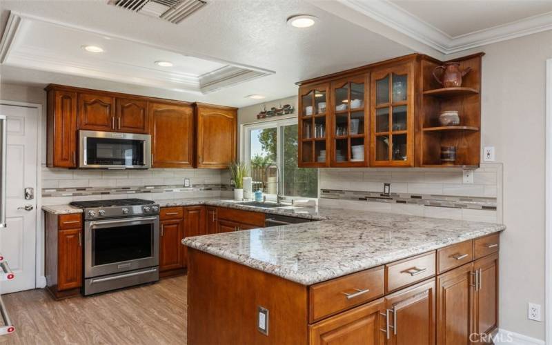 Beautifully reimagined chef's kitchen with stone counters, custome tile backsplash, gas range, convection oven, stainless sink and more.