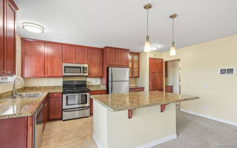 Spacious eat-in kitchen with counter height island and pendant lighting