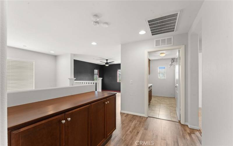 Top of stairs with a view of the laundry room and the loft.