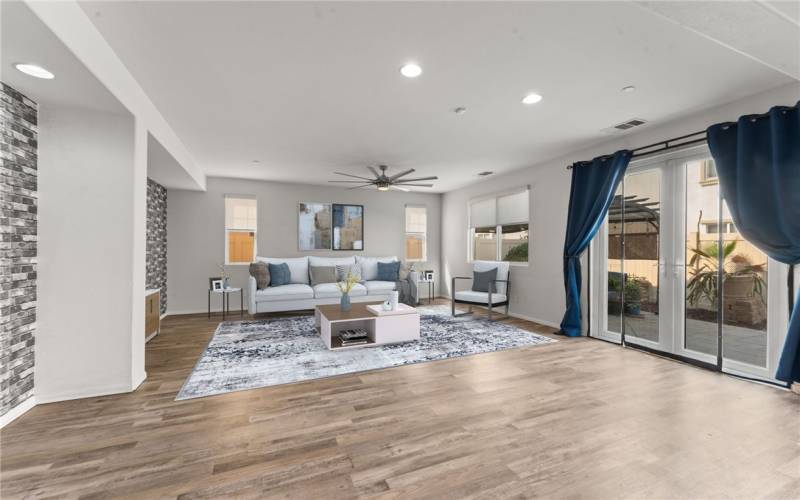 Virtual Staging. Enjoy this spacious and bright living area, featuring modern flooring, recessed lighting, and large windows that fill the space with natural light. The open layout seamlessly connects the living room to the dining area, creating a perfect setting for entertaining.