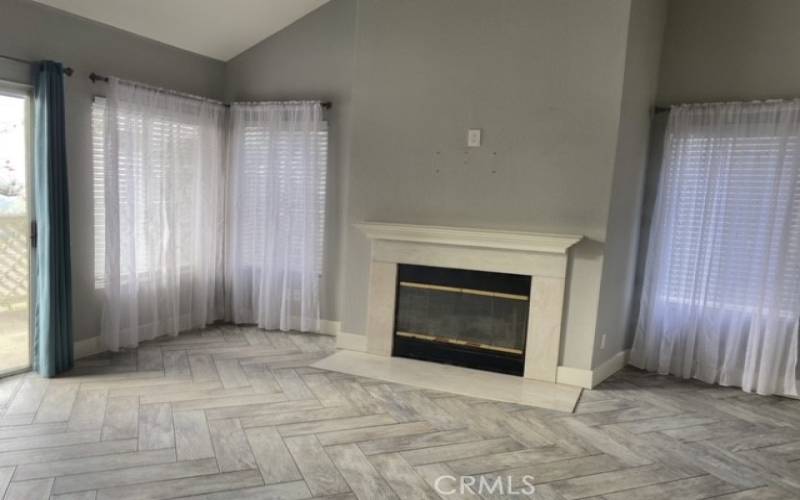 Nice Fireplace in Living Room with Lots of Windows and Sliding Door to Balcony