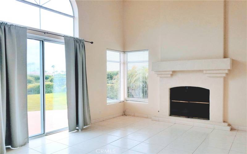 LIVING ROOM W/FIREPLACE VIEWS OVER LAWN TO GOLF GREENS