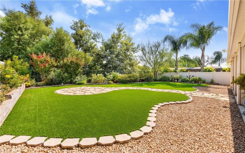 Low maintenance back yard has Lush Plantings with Multicolored flowers