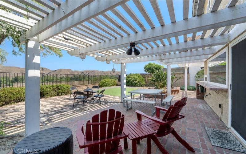 Large brick patio with lattice cover outside sliders from kitchen & family room.