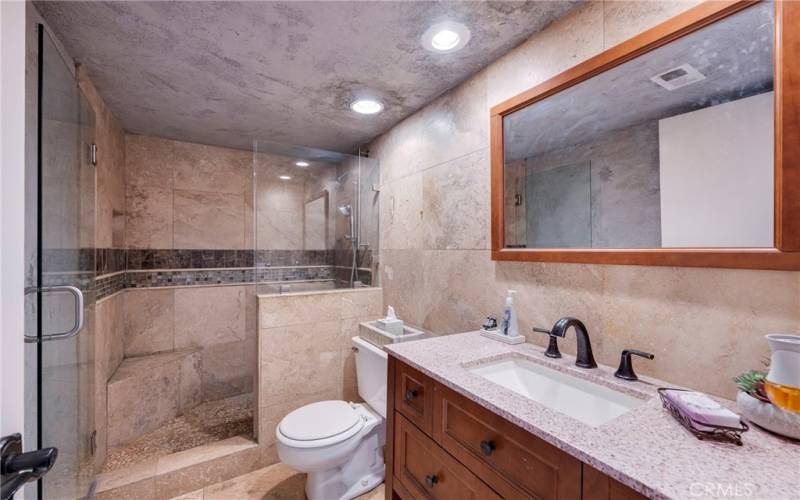 Beautifully tiled bath has step n shower & recessed lights.