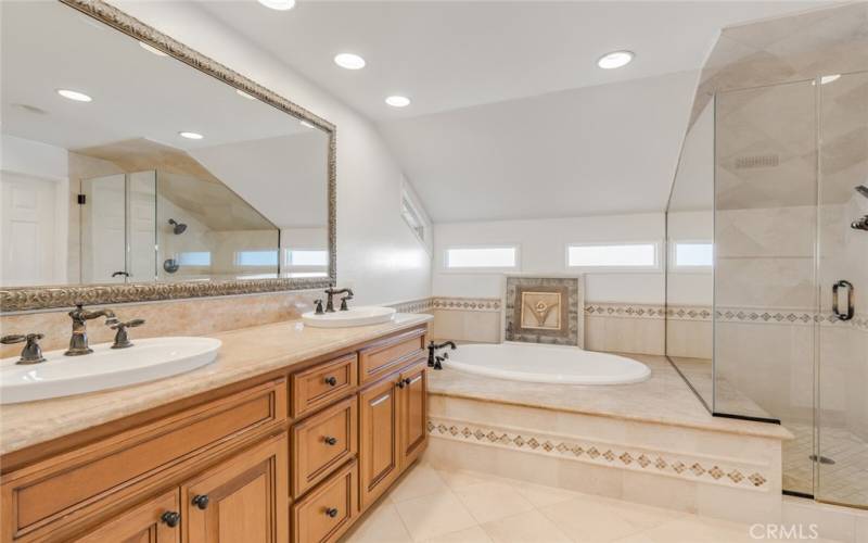 Main bathroom featuring dual sinks and a sunken tub