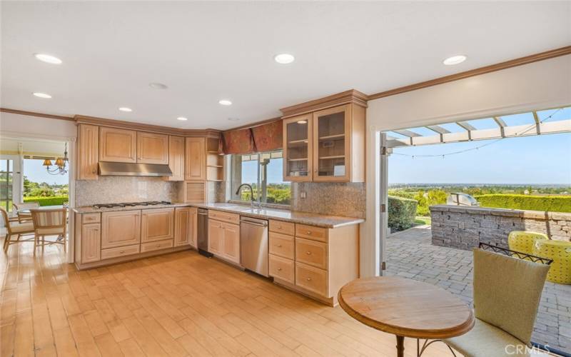 The kitchen opens to the back patio that features a built in BBQ