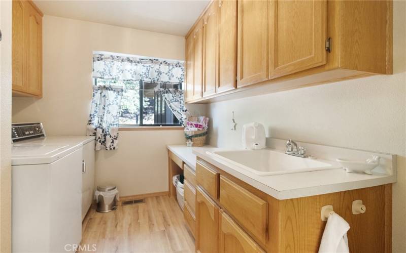 Laundry room with plenty of counter space and storage.