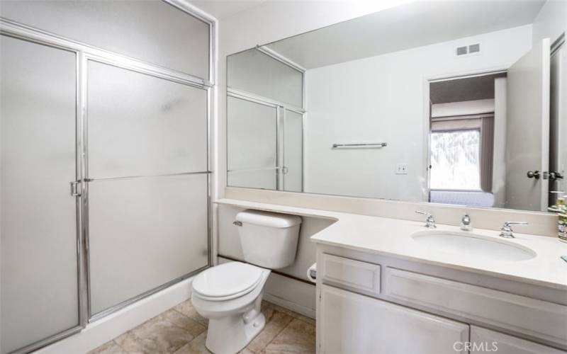 The spacious bathroom for the third bedroom. A full size walk in shower with glass doors, toilet and sink. A full size linen closet located in the bathroom.