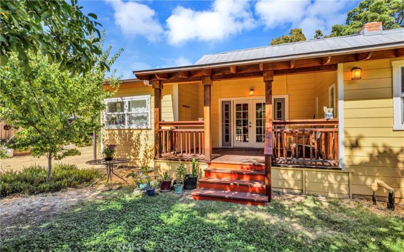 Second entrance through French doors to kitchen; spacious covered porch; plenty of room to relax, dine and enjoy the beauty of this property