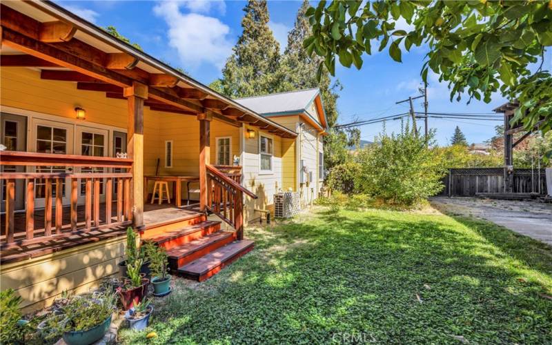 Side porch, looking towards street, there is a gateway to the front of the home, across from the yard is the spacious covered area