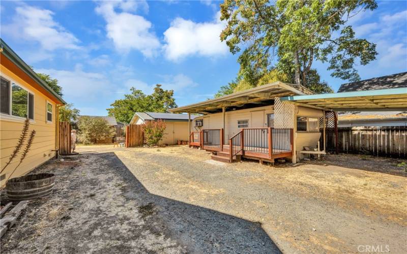 One of two entrances to the property, this is the south side of the home, guest trailer to the right, drive further back is the two car garage and back entry to the home.