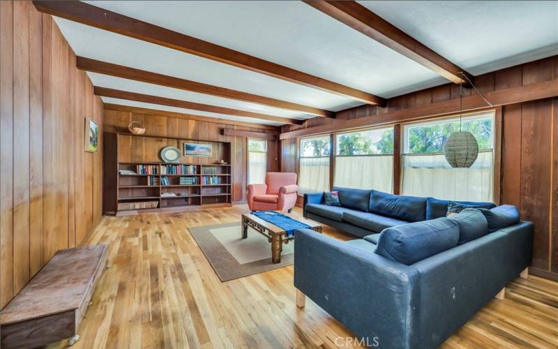 Living area with built in shelving, wood floors and wood burning fireplace