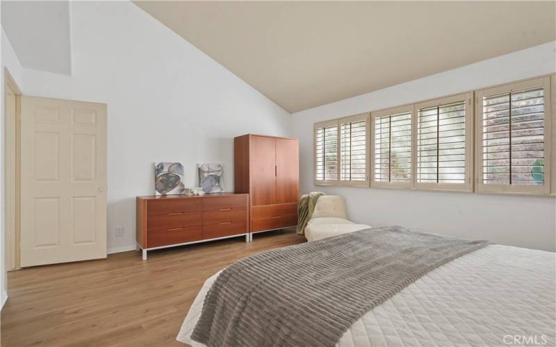 Primary suite with windows overlooking the patio yard
