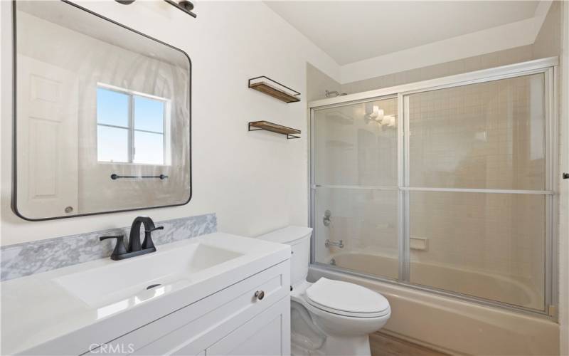 Ensuite bathroom attached to 1st bedroom with tub/shower combo