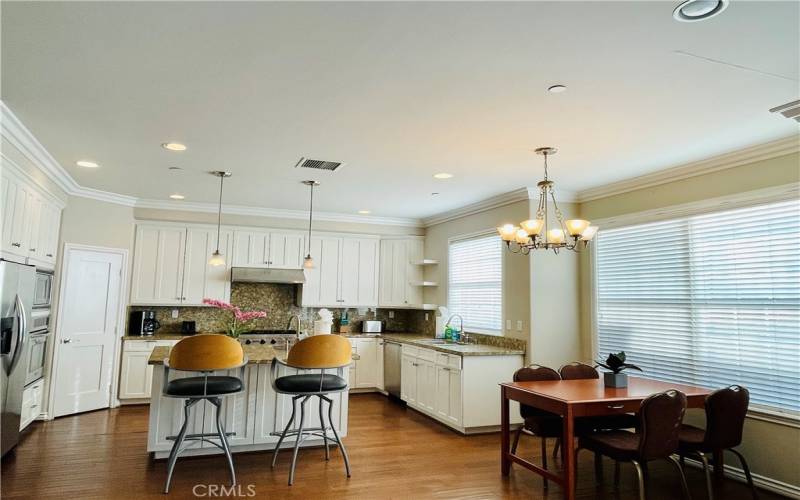 kitchen area with island, granite countertop, walk in panty, all steel less -steel appliances