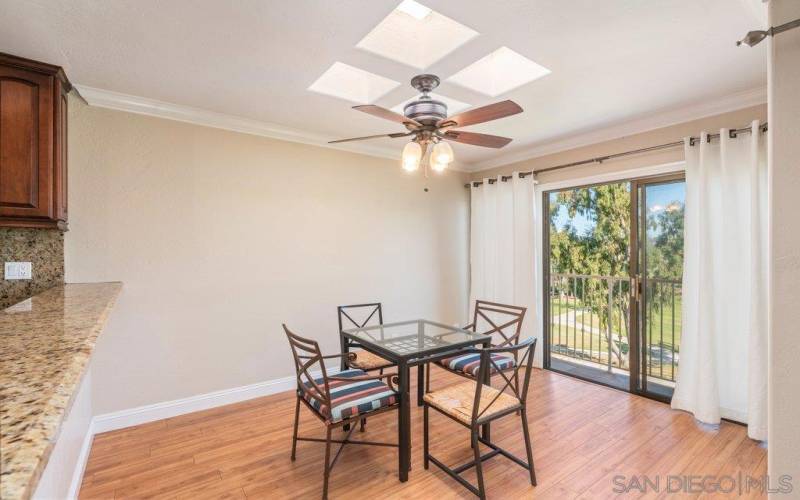 Dining area is well lit with natural light from skylight and bay window views.