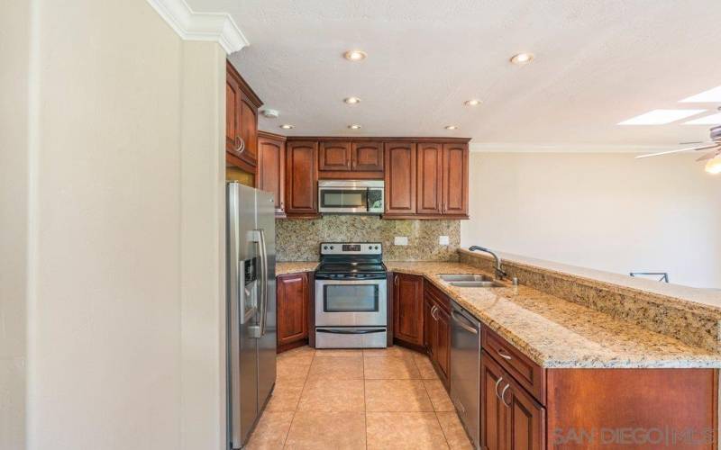 Upgraded kitchen with granite counter-tops, all appliances convey and cherry wood cabinets.