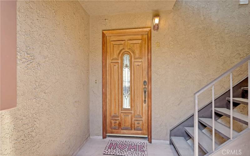 Private secure front door behind decorative iron foyer gates