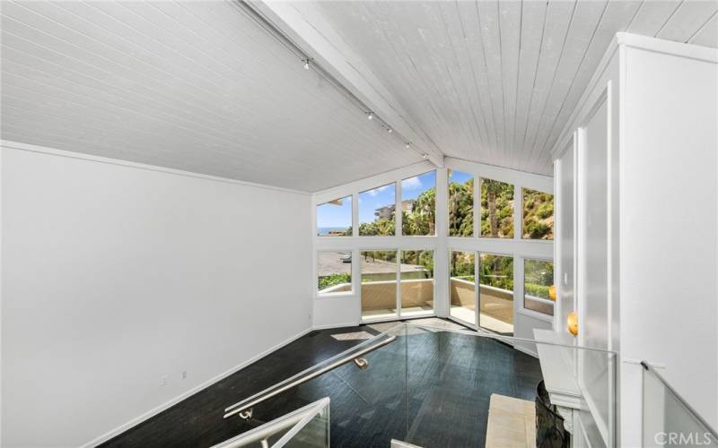 Ocean view living room with gas fireplace and vaulted ceilings