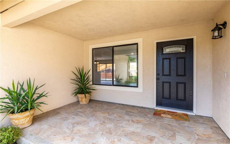 Beautiful front tiled porch entry. Covered from the rain and the heat of the day. Great place to chill on a warm summer night and very private with all the lush landscaping directly in front.