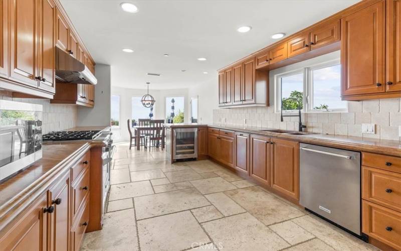 Stainless-Steel appliances, travertine flooring, wine fridge and epic ocean views from the kitchen and dining area.