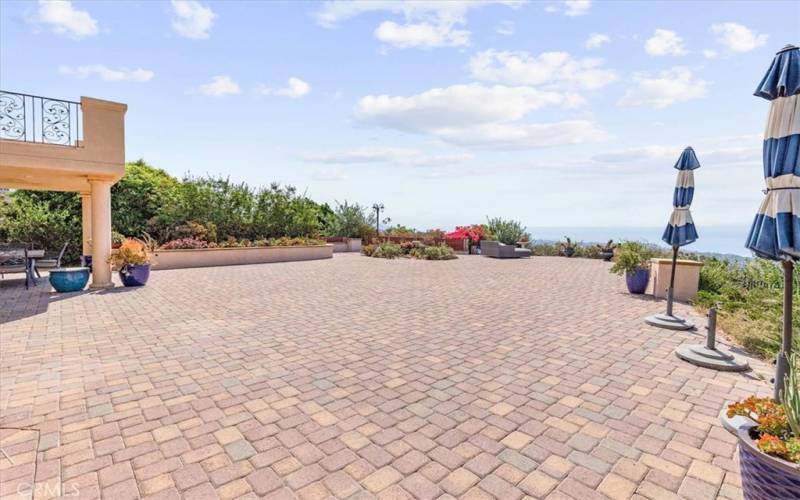 HUGE paver-stoned lot for entertaining. At the end of the pavers leads to stairs with a little putting green. (pictures coming soon)