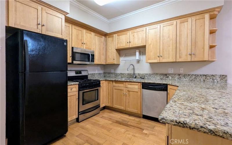 Kitchen with refrigerator, microwave, gas stove & oven, and dishwasher