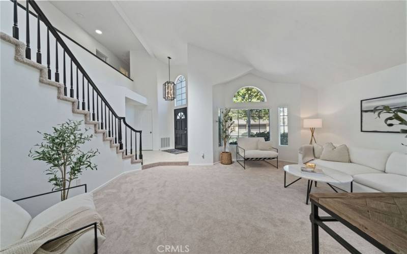 Formal Living Room with Vaulted Ceilings and Sweeping Staircase.