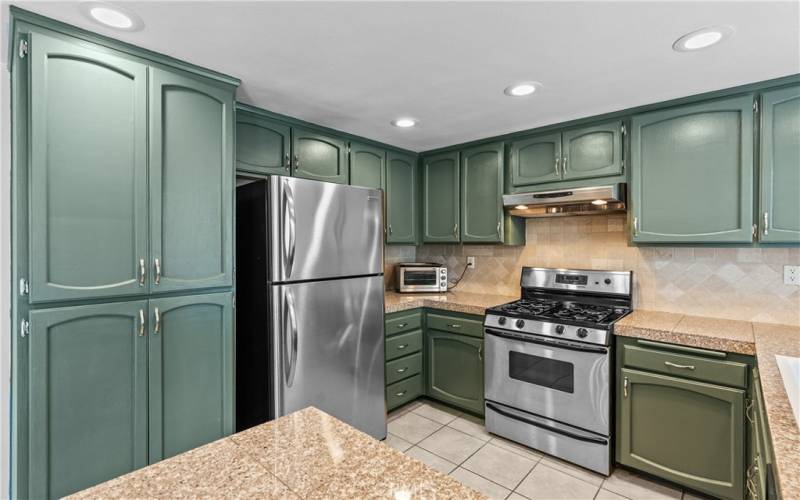 Clean cook's kitchen with granite tile counter tops, tons of cabinet storage and gas range/oven.