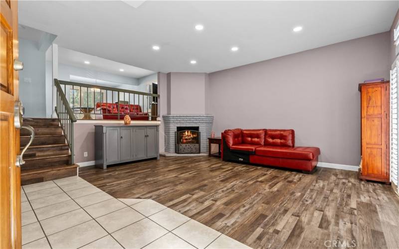 Living room with recessed lighting, a fireplace and high ceilings.