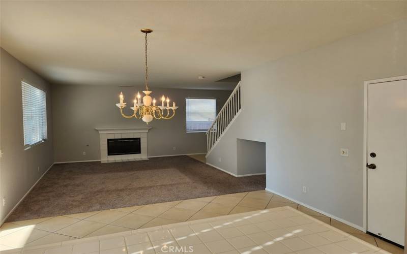 Open floorplan looking from kitchen into dining area and living room with fireplace .