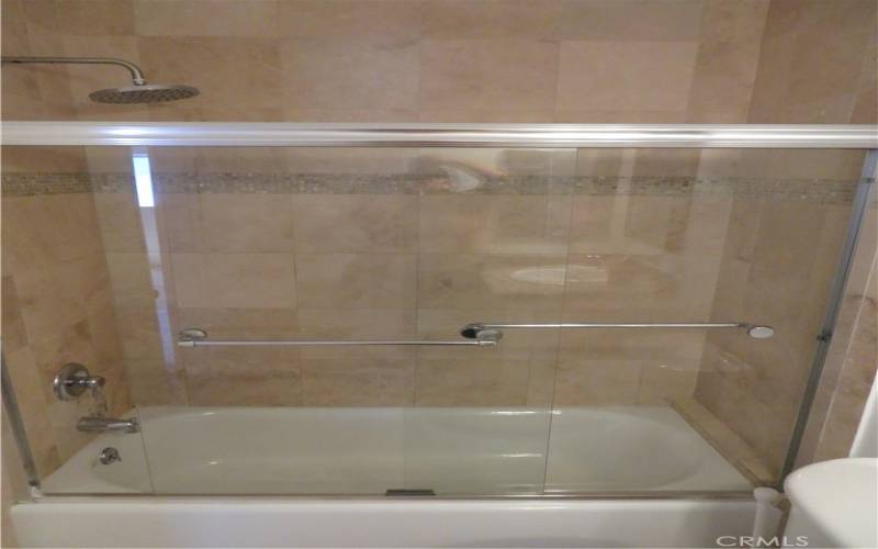 Shower and Bathtub, with glass shower Door.