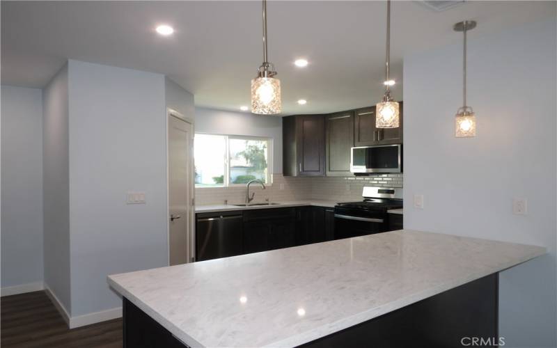 Quartz peninsula counter with pendant lights