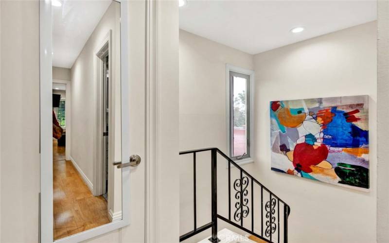 Staircase with Opening Window for Airflow. Linen Closet at the top of the Stairs with Mirror.